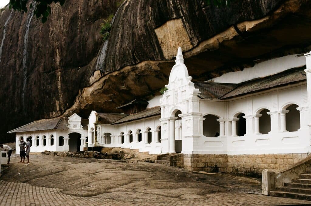 Dambulla Cave Temple in Sri Lanka beneath a massive rock overhang.