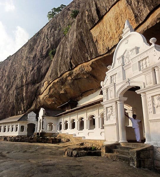 Dambulla Cave Temple beneath a massive rock overhang in Sri Lanka.