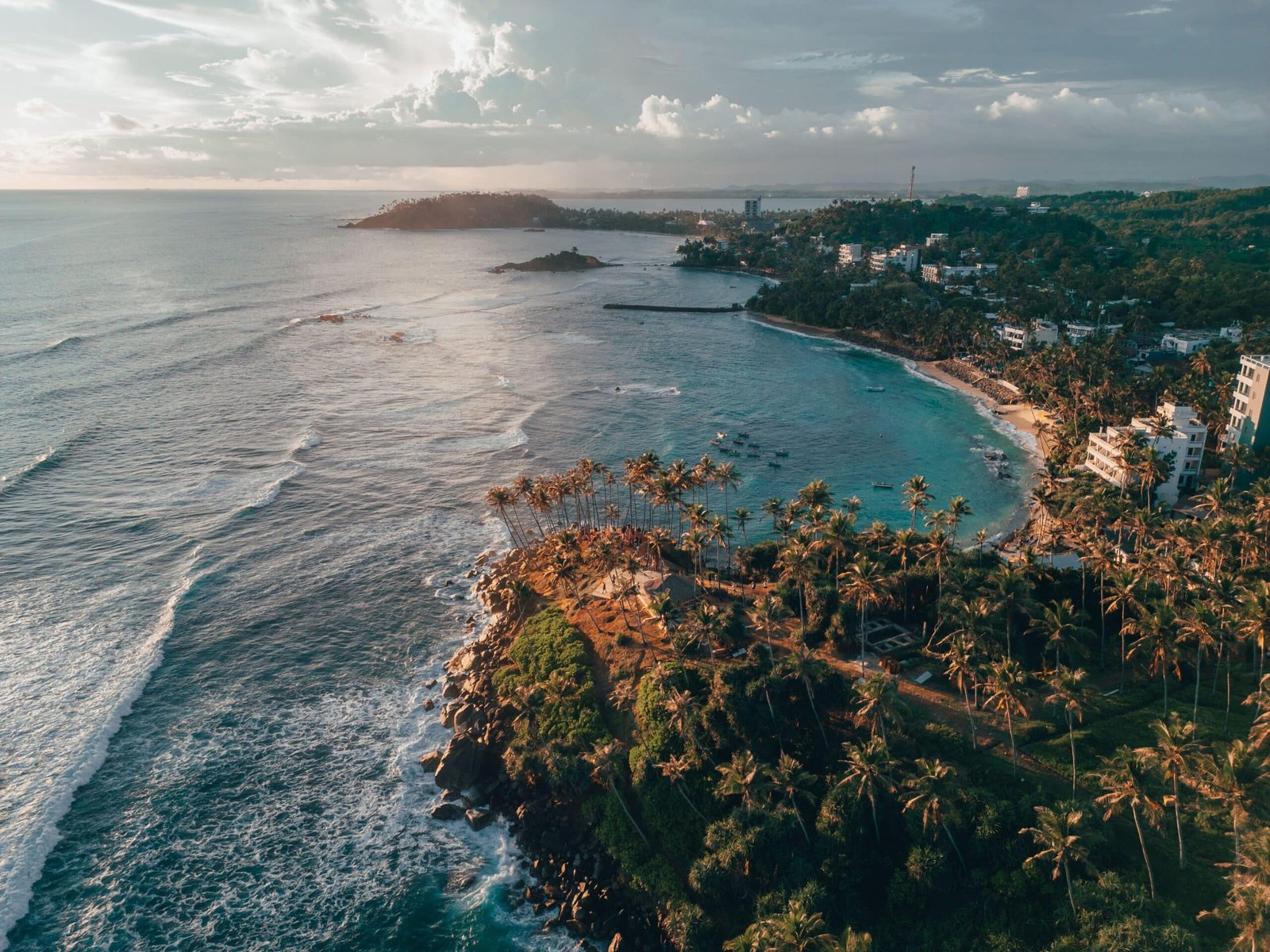 Aerial view of palm-lined Weligama Bay and coastal village in Sri Lanka.