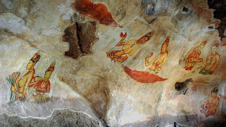 Ancient painted human figures adorn a weathered cave wall with faded red and orange pigments.