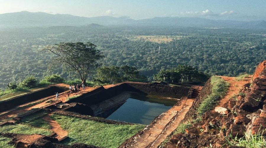 Ancient hillside ruins and water terraces overlooking a lush mountain valley.
