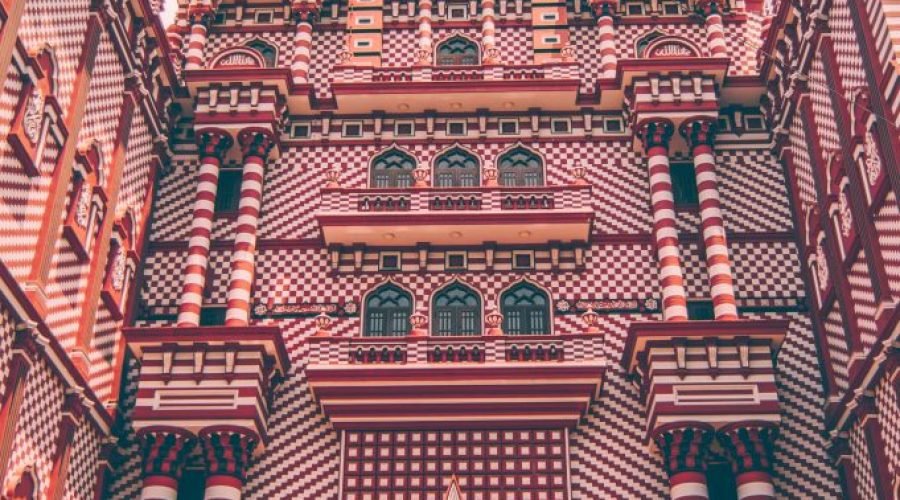 Ornate red-and-white Jami Ul-Alfar Mosque facade in Colombo, Sri Lanka.