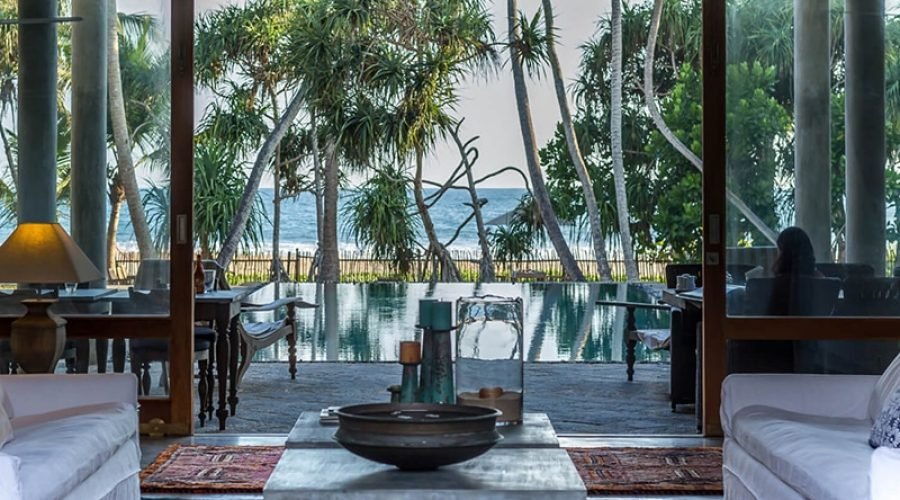 Luxury Sri Lanka villa living room overlooking a tropical pool and ocean.