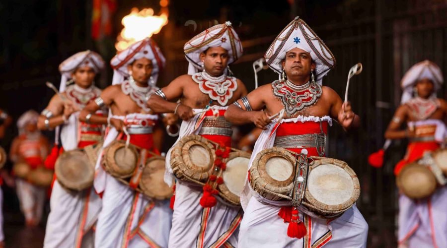 Traditional drummers in white and red costumes perform during a lively ceremonial procession.